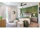 Cozy bedroom features green accent wall, ceiling fan, and ample natural light from the windows at 651 Melville Dr, Rock Hill, SC 29732