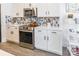 Modern kitchen featuring stainless steel appliances, white cabinets, mosaic backsplash, and wood grain flooring at 651 Melville Dr, Rock Hill, SC 29732