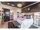 Bedroom featuring black ceiling, stylish wallpaper, gold bed frame, and modern sliding door to the bathroom at 651 Melville Dr, Rock Hill, SC 29732