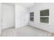 Bright bedroom featuring two windows, neutral colored walls and soft carpet at 737 Oak St, Charlotte, NC 28214
