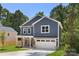Two-story home with a garage and covered porch, surrounded by mature trees and a landscaped yard at 737 Oak St, Charlotte, NC 28214