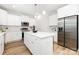 Modern kitchen with white cabinets, an island with seating, and stainless steel appliances at 737 Oak St, Charlotte, NC 28214