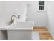 Laundry room featuring a utility sink, a window and light wood colored floors at 737 Oak St, Charlotte, NC 28214