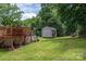 Backyard showing deck of in-ground pool, storage shed, fenced yard with lush green lawn at 792 Carolina Mill Cir, Lincolnton, NC 28092