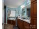 A well-lit bathroom with double sinks, bathtub, granite countertop, and essential toiletries at 792 Carolina Mill Cir, Lincolnton, NC 28092