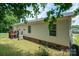 View of the side exterior, showing the house siding, an air conditioning unit, and partial deck at 792 Carolina Mill Cir, Lincolnton, NC 28092