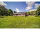 Expansive backyard with a lush lawn, mature trees, and a brick home with patio at 801 Witmore Rd, Wingate, NC 28174