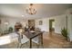 Open-concept dining room featuring wood floors, elegant lighting, and access to the living area at 801 Witmore Rd, Wingate, NC 28174