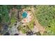 Aerial view of the inground pool with spa surrounded by patio furniture, rock landscaping, and lush trees at 9184 Greenwood Rd, Terrell, NC 28682