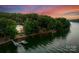 A sunset aerial view of a multi-story home with a private dock on the lake at 9184 Greenwood Rd, Terrell, NC 28682