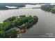 Aerial view showcases the home on a wooded lot, complete with a private dock and expansive lake frontage at 9184 Greenwood Rd, Terrell, NC 28682