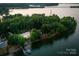 Aerial view of an estate nestled by the lake with private dock, surrounded by lush green trees and a pristine shoreline at 9184 Greenwood Rd, Terrell, NC 28682