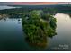 An aerial view shows a lakefront home and surrounding trees along a shoreline in a calm lake setting at 9184 Greenwood Rd, Terrell, NC 28682