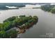 An aerial shot showcases the boundaries of the land with a lakefront view, trees and house at 9184 Greenwood Rd, Terrell, NC 28682