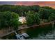 An aerial shot featuring a lakeside home, complete with a private dock and beautifully illuminated exterior at 9184 Greenwood Rd, Terrell, NC 28682