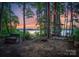 Backyard with bench and stone sitting area offers a relaxing view of the lake amid the trees at 9184 Greenwood Rd, Terrell, NC 28682