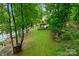Beautiful backyard with lush lawn and trees leading to the waterfront at 9184 Greenwood Rd, Terrell, NC 28682