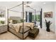 Spacious main bedroom featuring a large four-poster bed, neutral colors, and windows overlooking a wooded backyard at 9184 Greenwood Rd, Terrell, NC 28682