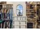 Well-organized walk-in closet with custom shelves for shoes, folded towels, and hanging clothes under an arched window at 9184 Greenwood Rd, Terrell, NC 28682