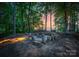 A captivating fire pit area is surrounded by mature trees, ideal for cozy evenings outdoors at 9184 Greenwood Rd, Terrell, NC 28682