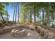 Outdoor fire pit area with a stone surround and seating, overlooking the lake at 9184 Greenwood Rd, Terrell, NC 28682
