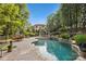 Resort-style pool with waterfall feature, brick patio, and beautiful landscaping at 9184 Greenwood Rd, Terrell, NC 28682