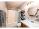 Well-lit bathroom features a tub and shower combination with vanity and round mirror at 102 Brandywine Ne Dr # O-3, Conover, NC 28613