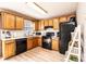 Kitchen with oak cabinets, white counters, sleek black appliances, and modern laminate flooring at 102 Brandywine Ne Dr # O-3, Conover, NC 28613