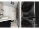 Modern bathroom featuring a vanity, a marble-tiled shower/bath, and a stackable washer and dryer at 103 Fleetwood Rd, York, SC 29745