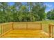 A scenic deck view of a fenced backyard with mature trees and lush green landscape at 105 Churchill Dr, Kings Mountain, NC 28086