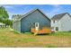 View of the back of a blue home with wood deck overlooking the lawn and features classic design at 105 Churchill Dr, Kings Mountain, NC 28086