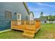 A close up of the wood deck area with a white door, steps, and view of the large back yard at 105 Churchill Dr, Kings Mountain, NC 28086