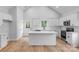 Clean white kitchen with island, white backsplash, stainless appliances, and bright windows at 105 Churchill Dr, Kings Mountain, NC 28086