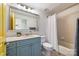 Cozy bathroom featuring a blue vanity, large mirror, shower-tub, and tiled floors at 115 E Park Ave # 409, Charlotte, NC 28203