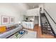 Open-concept living area with modern decor, a sleek staircase, and a breakfast bar for casual dining at 115 E Park Ave # 409, Charlotte, NC 28203