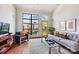 Bright living room boasts a large window, yellow door, and comfortable seating, creating a welcoming atmosphere at 115 E Park Ave # 409, Charlotte, NC 28203