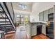 Open living space with a modern staircase, kitchen, and seating area with natural light from large windows at 115 E Park Ave # 409, Charlotte, NC 28203