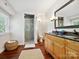 Bright bathroom featuring a double vanity, granite countertop, glass enclosed shower, and hardwood floors at 1219 Pinecrest Ave, Charlotte, NC 28205