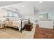Bedroom featuring a metal bed frame with white linens, hardwood floors, and an antique trunk at 1219 Pinecrest Ave, Charlotte, NC 28205