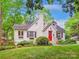 Charming painted brick home with a bright red front door, a chimney, and lush landscaping at 1219 Pinecrest Ave, Charlotte, NC 28205