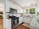 Bright kitchen boasting stainless steel appliances, granite countertops, and white cabinetry at 1219 Pinecrest Ave, Charlotte, NC 28205