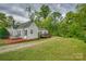 Expansive backyard with lush green grass, a gravel driveway, and well-maintained landscaping for outdoor enjoyment at 123 N Poston St, Shelby, NC 28150