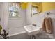 Compact bathroom featuring a sink, tub, and a window for natural light at 123 N Poston St, Shelby, NC 28150