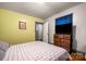 Relaxing bedroom featuring hardwood floors, soft yellow walls, and a TV for comfort and convenience at 123 N Poston St, Shelby, NC 28150