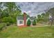 Charming single-story home with green roof, tidy landscaping, and a chain-link fence at 123 N Poston St, Shelby, NC 28150