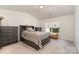 Comfortable bedroom featuring matching dressers, plush carpet, and natural light from the window at 1405 Amberlight Cir, Salisbury, NC 28144