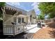 Backyard deck with white wood flooring and pergola, featuring seating and a grill at 14218 Springsure Ct, Huntersville, NC 28078