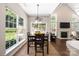 Cozy dining area adjacent to a living space with a fireplace and views of the backyard at 14218 Springsure Ct, Huntersville, NC 28078
