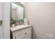 Stylish powder room features a decorative mirror and a sink with cream colored cabinet at 14218 Springsure Ct, Huntersville, NC 28078