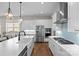 Open kitchen features stainless appliances, a large island, modern lighting, white cabinets, and hardwood floors at 14531 Crosswater Ln, Charlotte, NC 28278